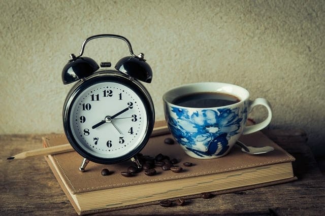 一杯のコーヒーと目覚まし時計